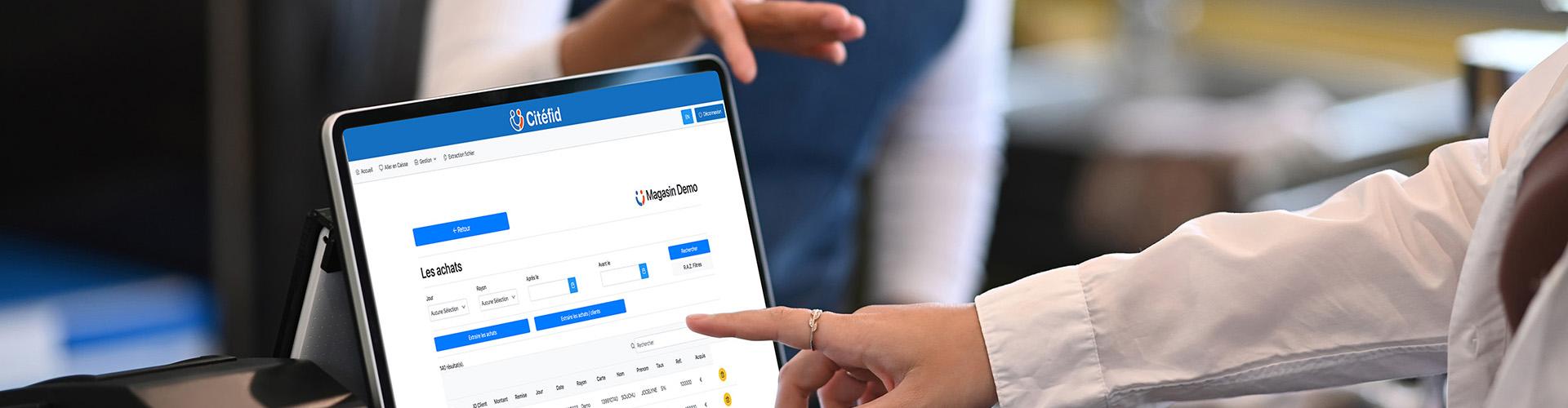 Une main tendue montre un ordinateur avec la licence Citefid ouverte.