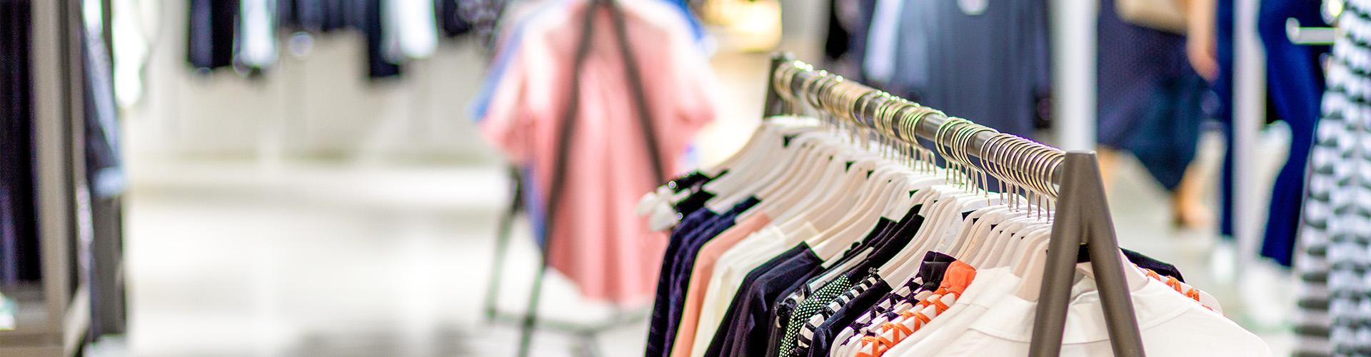 Une boutique de vêtements prêt-à-porter où l'on peut voir des vêtements alignés sur un présentoir.